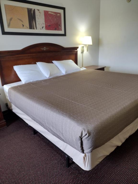 Un dormitorio con una cama grande con almohadas blancas. en Hoosier Inn- Portland, en Portland