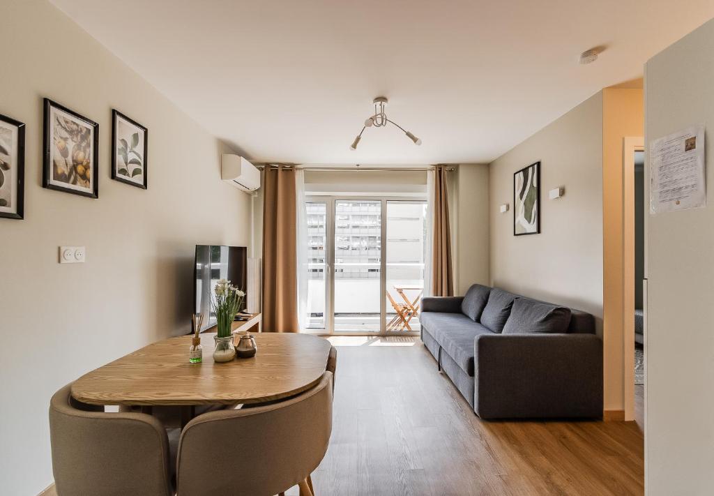 un salon avec une table et un canapé dans l'établissement T2 Tête d’Or Confort + Parking gratuit, à Villeurbanne