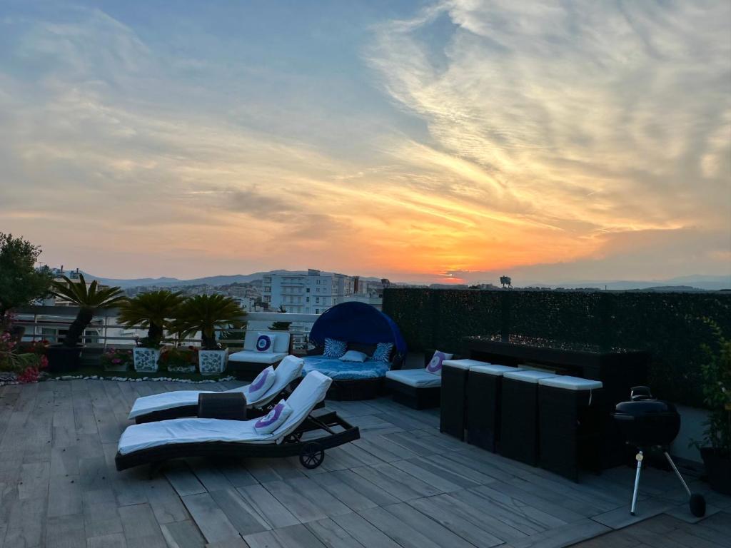 a rooftop patio with two lounge chairs and a sunset at CANNES CROISETTE Sea & Sky in Cannes