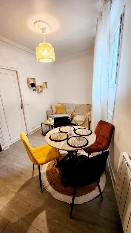 un salon avec une table et des chaises dans l'établissement Appartement cosy situé dans un quartier calme, à Villejuif