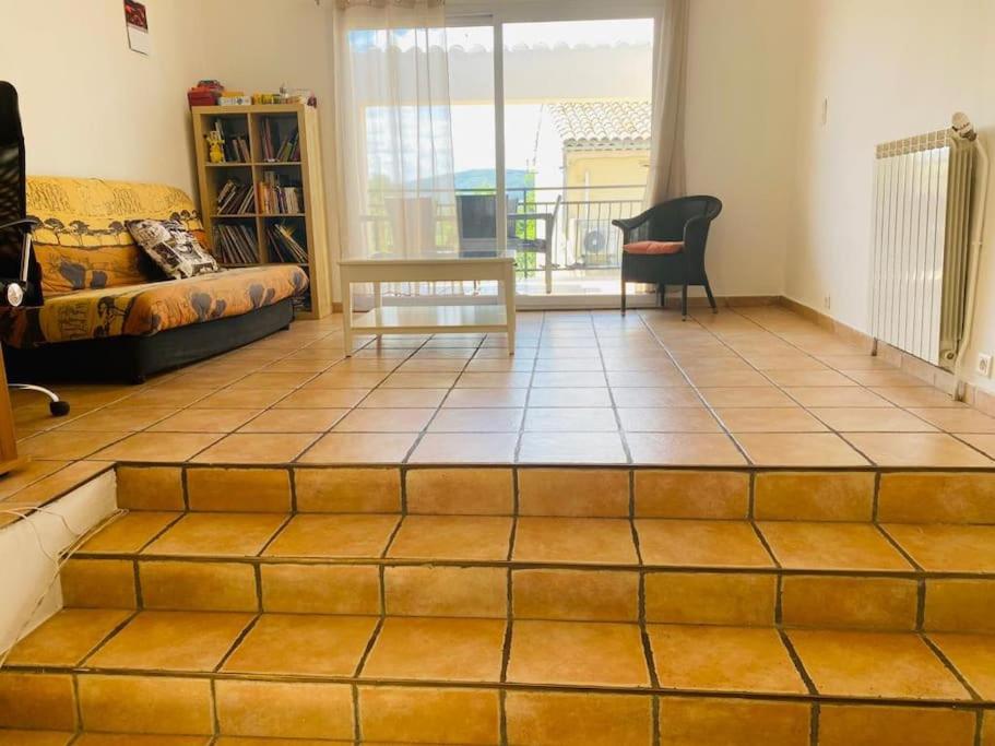 - un salon doté de carrelage et d'un canapé dans l'établissement Charmante maison de village, à Villelaure