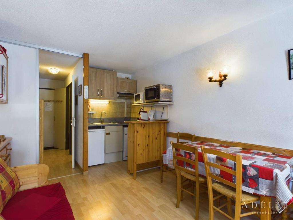 une petite cuisine et salle à manger avec une table et des chaises dans l'établissement Studio cosy avec balcon, à 50m des pistes, 4 pers, au pied des commerces - FR-1-398-628, à Montvalezan