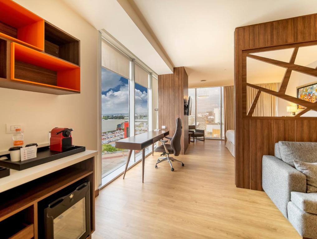 ein Wohnzimmer mit einem Sofa und einem Schreibtisch in der Unterkunft Metria Hotel in León