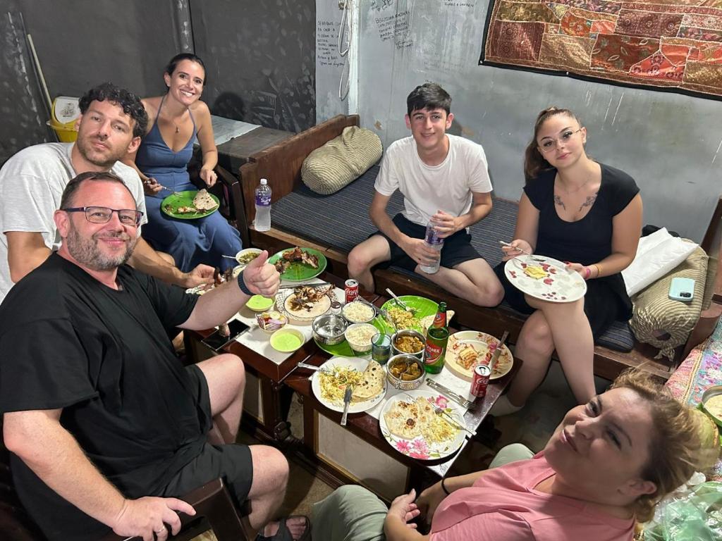 a group of people sitting around a table eating food at Little prince guest house & homestay in Bikaner