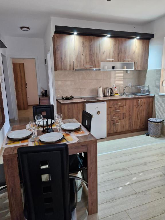 a kitchen with wooden cabinets and a table with plates on it at Apartman Curcic 1 in Soko Banja