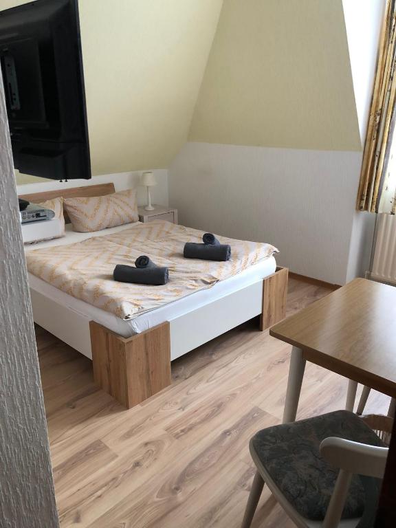 a bedroom with a bed with a tv and a table at Zimmer Leuchtturm in Dagebüll