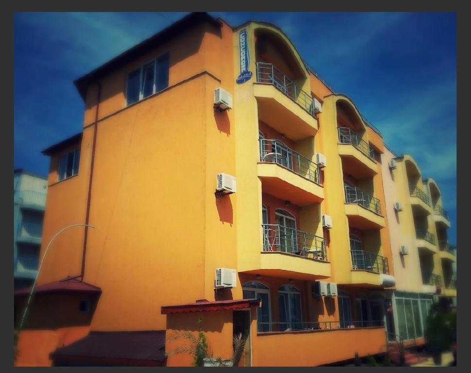 ein gelbes Gebäude mit Balkon an der Seite in der Unterkunft Concordia Plaza 2 in Primorsko