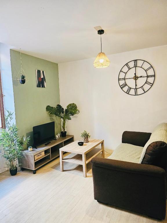 un salon avec un canapé et une horloge au mur dans l'établissement 49 studio centre-ville BOX A BAGAGES GRATUITS, à Carcassonne