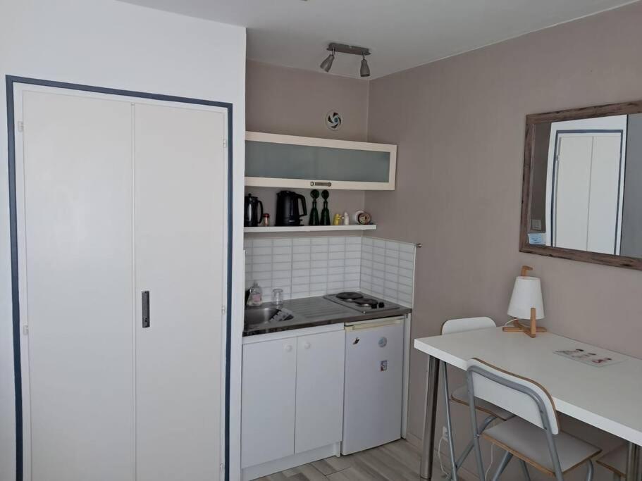 - une cuisine avec un comptoir, un évier et une table dans l'établissement Studio Arc En Ciel 2 - 27 allée des pinons - 6-1, à Saint-Jean-de-Monts