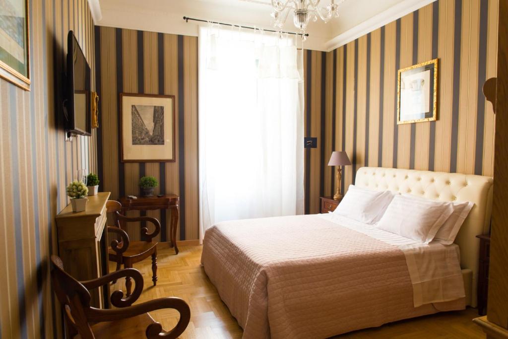 a bedroom with a bed, chair and a lamp at Landlord in Trastevere in Rome