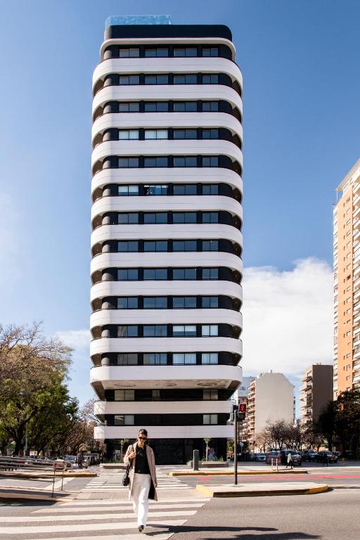 a person walking in front of a tall building at Top Rentals Nuñez in Buenos Aires