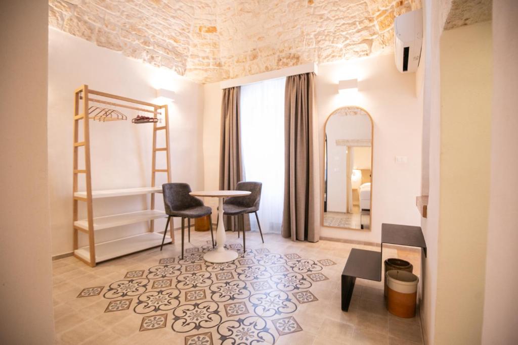 a room with a table and chairs and a mirror at Casa Rina in Ostuni