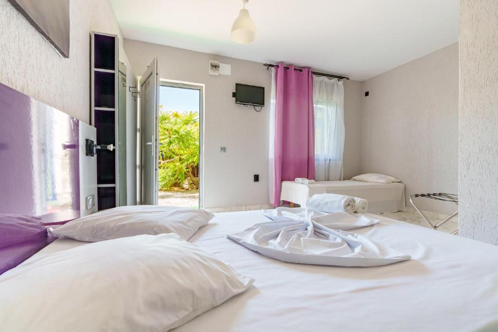 a bedroom with two beds and a tv on the wall at Deea Marii Costinesti in Schitul
