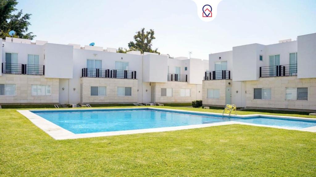 a swimming pool in front of a large building at Modern house in Yautepec in Yautepec