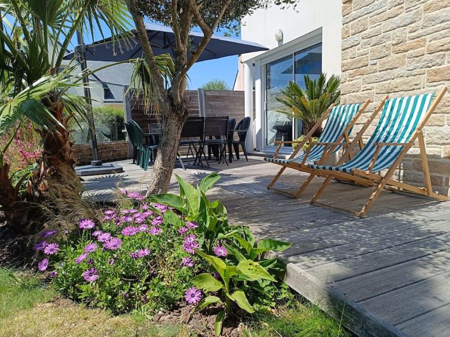 2 chaises et une table sur une terrasse fleurie dans l'établissement ty koz, à Erdeven
