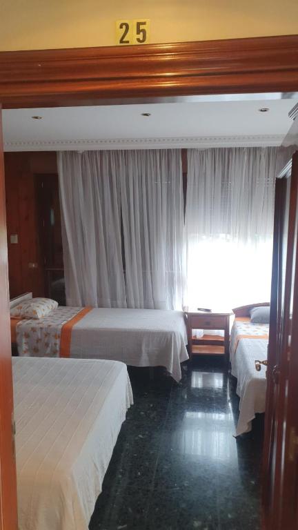 A bed or beds in a room at Pensión ** Abacá Gijón