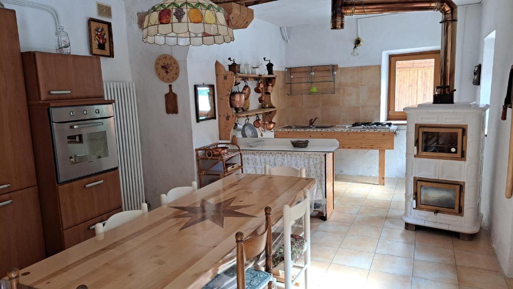 Una cocina con una mesa de madera y un comedor. en Antica Villa Piave, en Perarolo di Cadore