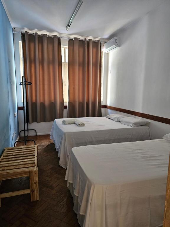 a room with two beds and a window at Nomads Hostel Multicultural & Coworking in Salvador