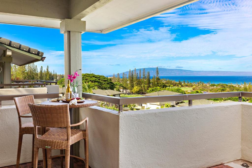 a balcony with a table and chairs and a view of the ocean at Kapalua Golf Villa 23T 4&5 in Kahana