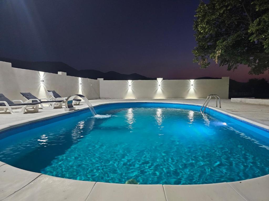 a swimming pool at night with lights on at Vila za odmor Svitavac in Trebinje