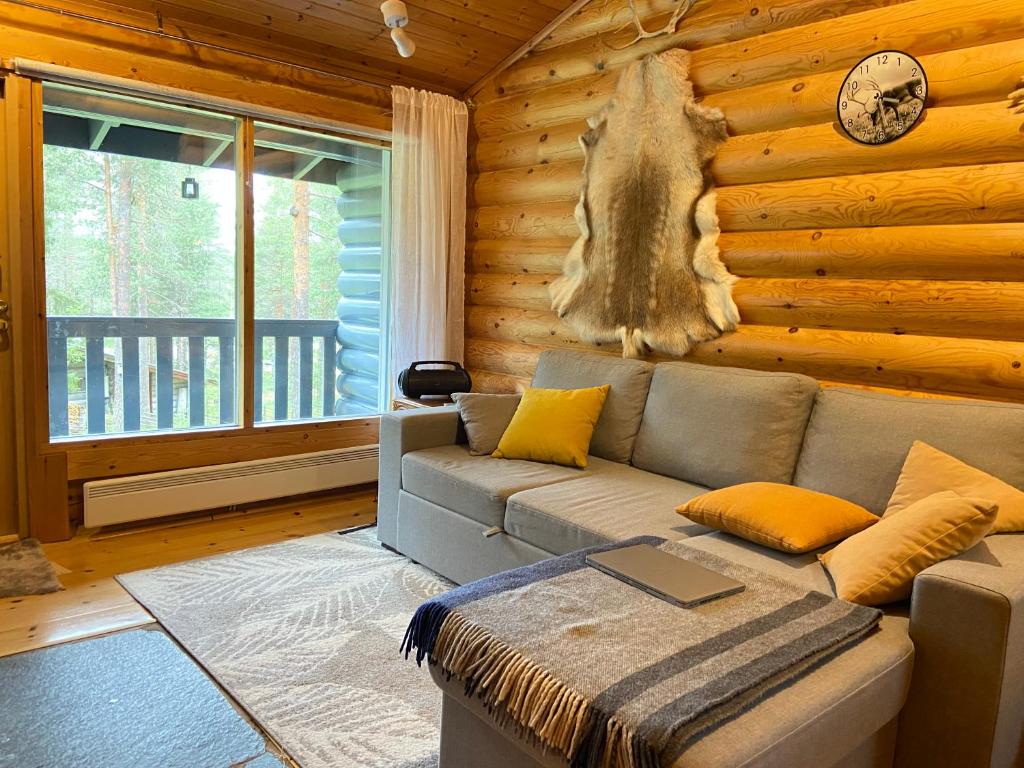 a living room with a couch in a log cabin at Lapland Chalet Lomalaavu in Suomutunturi