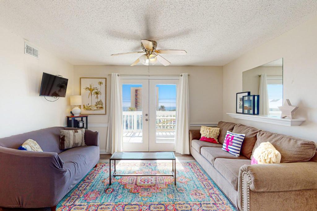 a living room with two couches and a ceiling fan at Moonraker 35 in Gulf Shores
