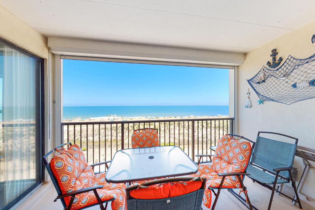 a table and chairs on a balcony with a view of the ocean at Breakaway East 512 in Ocean City