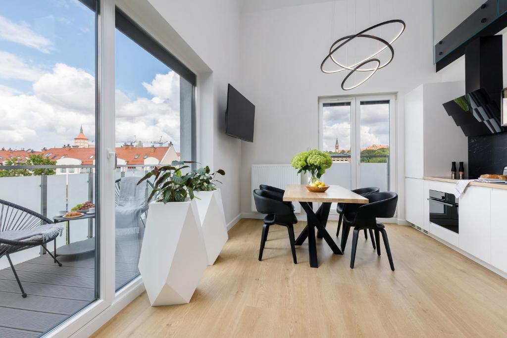 a kitchen and dining room with a table and a balcony at Grand House in Olsztyn