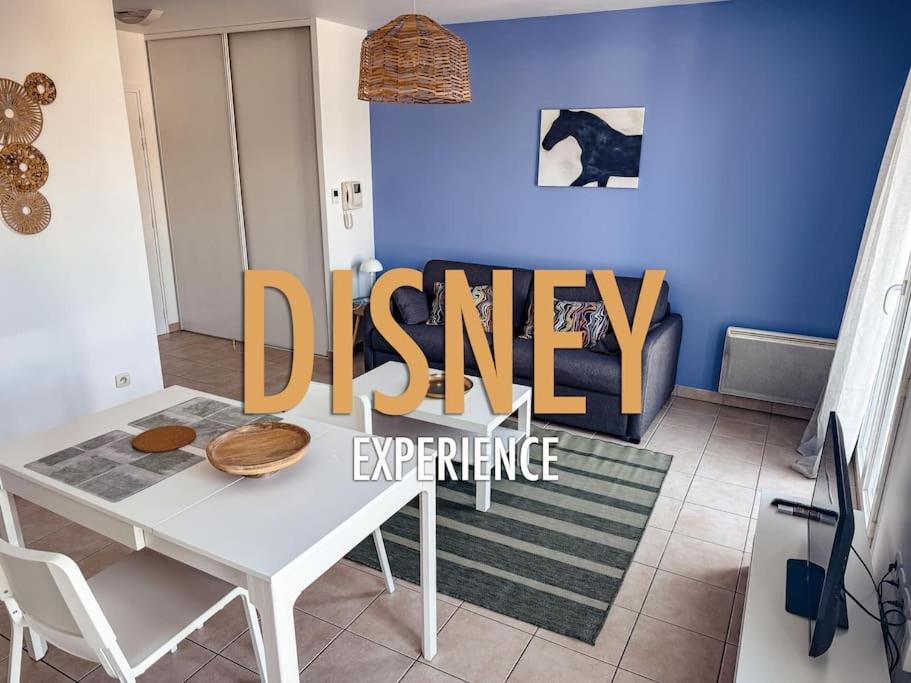 une salle à manger avec une table blanche et un mur bleu dans l'établissement Studio Cosy proche de Disney, à Magny-le-Hongre