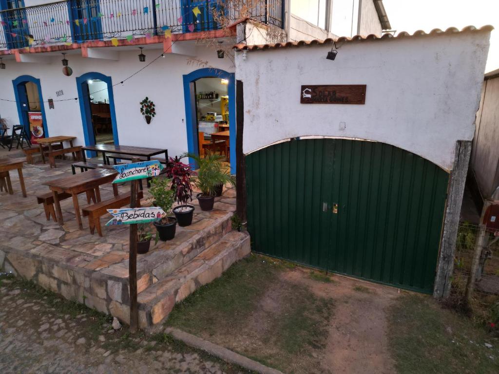 a green gate in front of a building with a table at Solar Maria Gomes - Lavras Novas MG in Lavras Novas