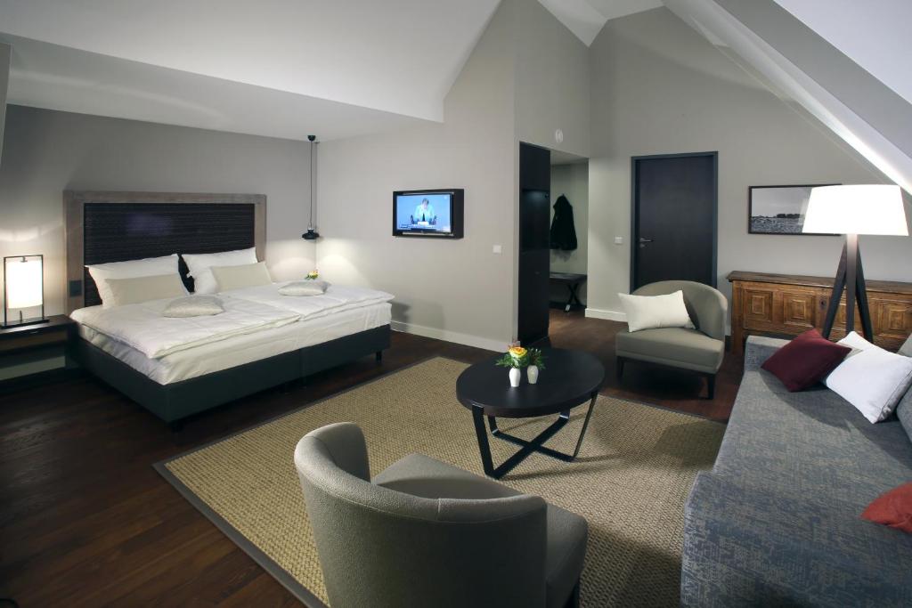 a bedroom with a bed and a living room at Hotel am Fischmarkt in Rheinberg