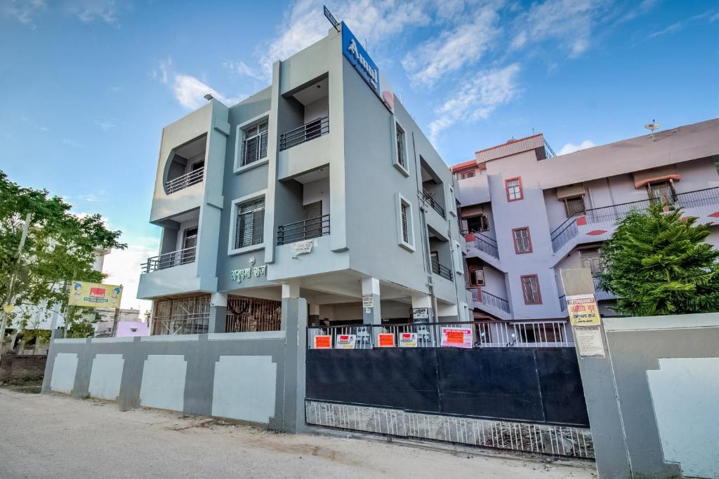 a white building with a blue sign on it at SPOT ON Hotel Rakesh International in Dānāpur