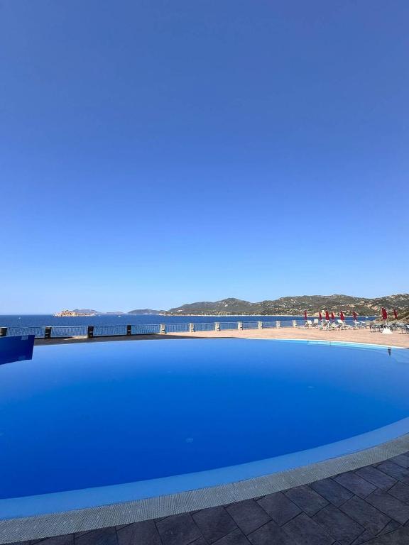 a blue swimming pool with the beach in the background at Ste.Mar Apartments in Teulada