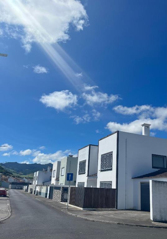 a row of white buildings on a street at Casa da Estrela in Ribeira Grande