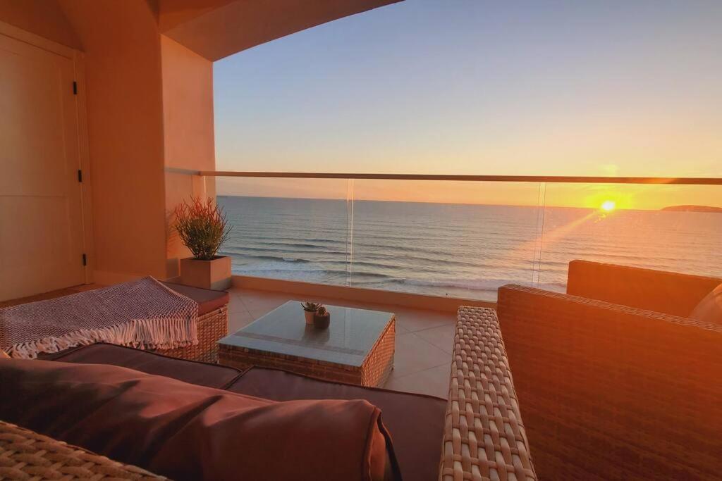a living room with a view of the ocean at BEACH FRONT CONDO, PRIVATE BEACH and AMAZING VIEWS!! in Los Cuatro Hermanos