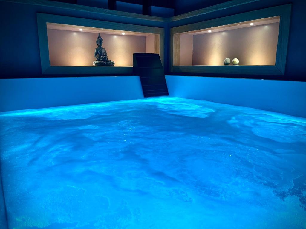 a room with a blue bed with two windows at Sumaiè Suite - Wellness in Salento in Mesagne