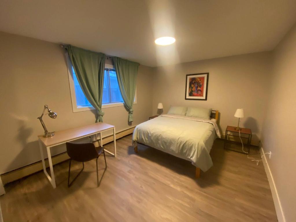 a bedroom with a bed and a desk and a window at Brand New Modern Flat 2br1ba Whyte And University in Edmonton