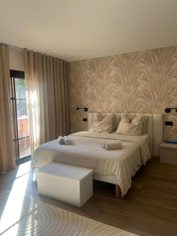 - une chambre avec un grand lit blanc et une grande fenêtre dans l'établissement Charming Villa, à Mougins