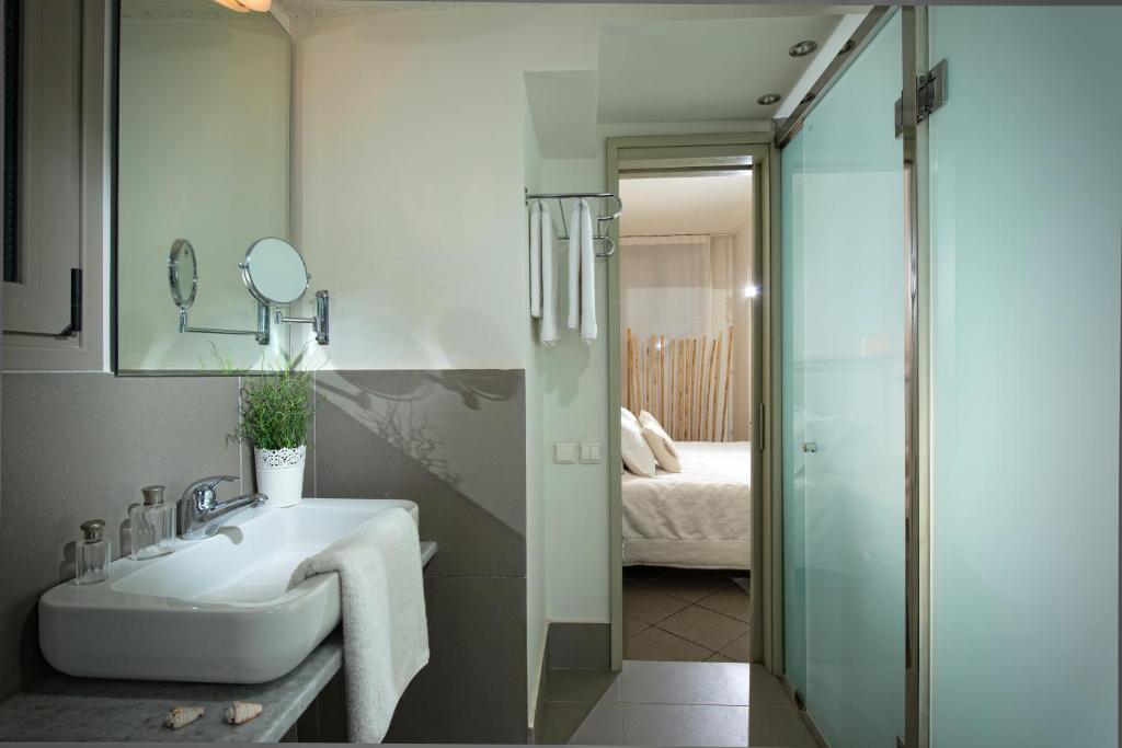 a bathroom with a sink and a glass shower at Skajado Holiday Apartments in Stalís