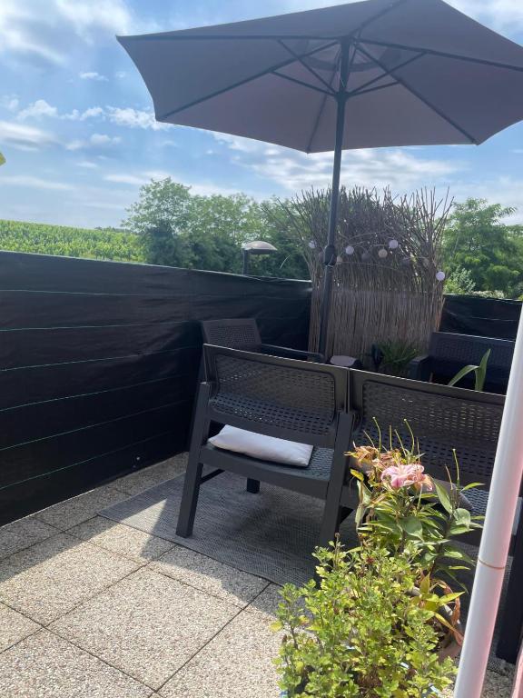 - une chaise et un parasol sur la terrasse dans l'établissement Appartement 2 chambres, à Artigues-près-Bordeaux