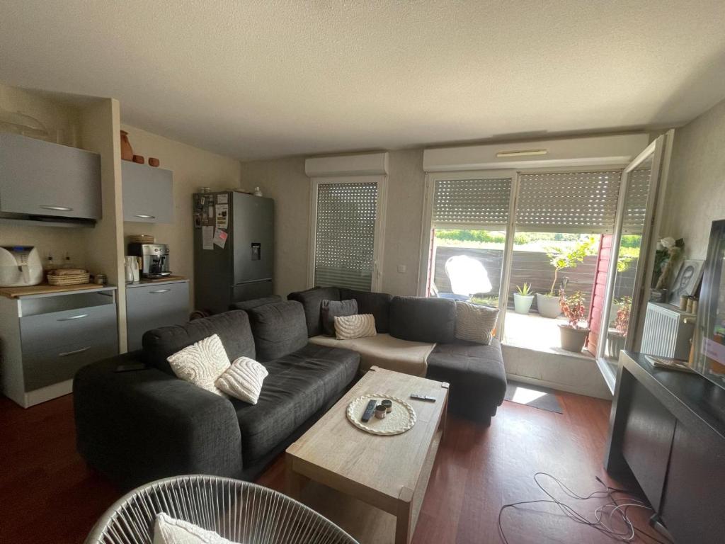 ein Wohnzimmer mit Sofa und Tisch in der Unterkunft Appartement 2 chambres in Artigues-près-Bordeaux