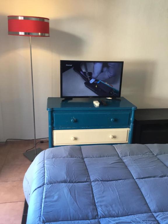 a bedroom with a blue dresser with a tv on it at Terraza y sol in Buenos Aires