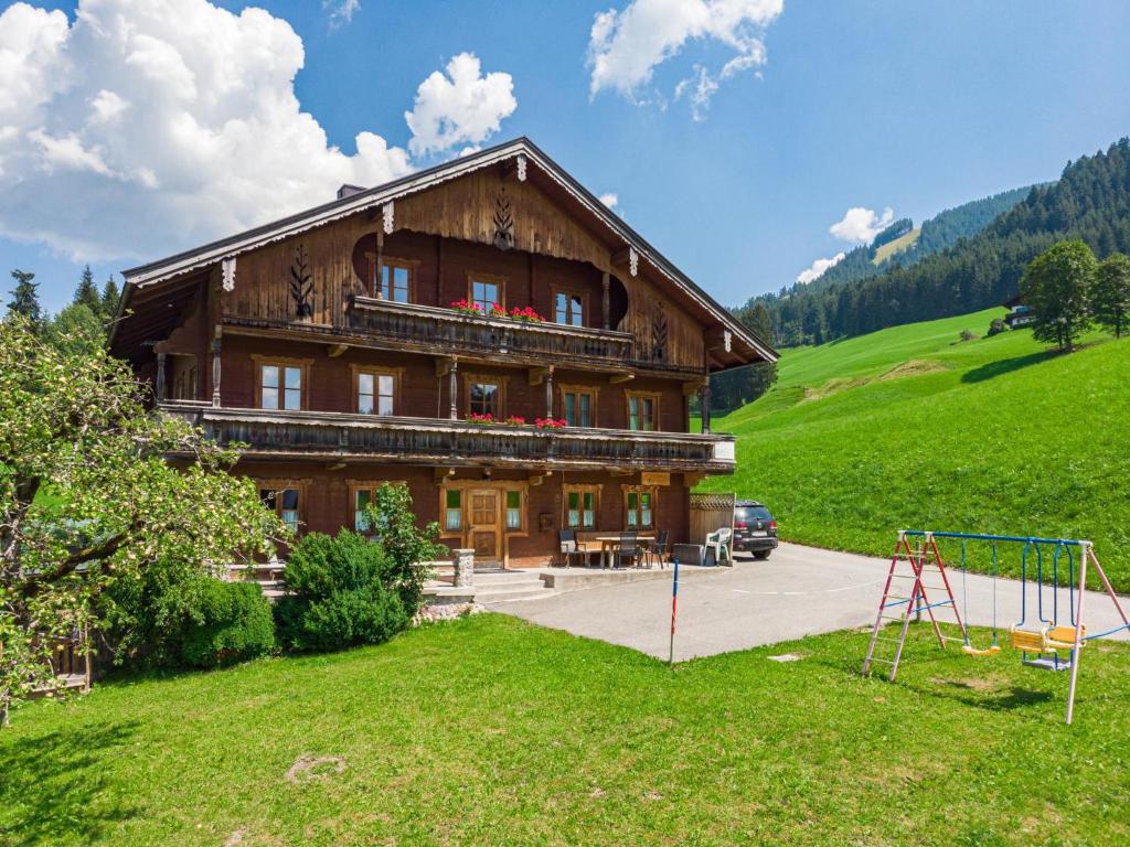 a large wooden building with a playground in front of it at Feilgrub 2 in Bichling