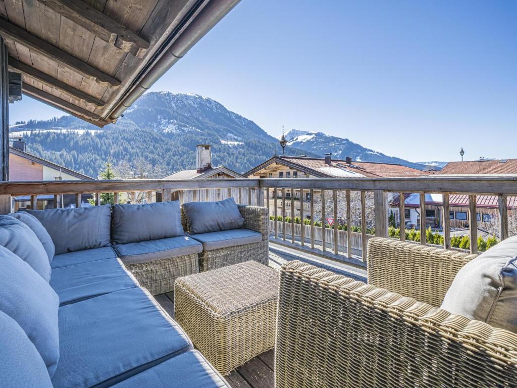 a patio with a couch and chairs on a balcony at Chalet Adriana in Kirchberg in Tirol