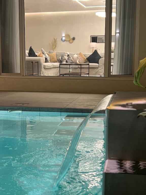 a swimming pool with a couch in a living room at Cove Chalet 1شاليه كوڤ in Al Ahsa