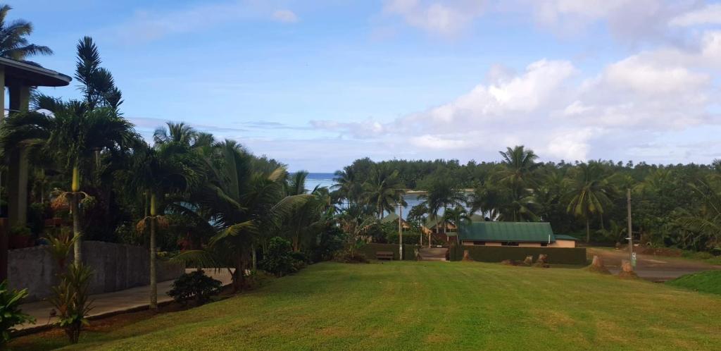 a yard with a green lawn with palm trees at Muri Pittman Sunrise in Titikaweka