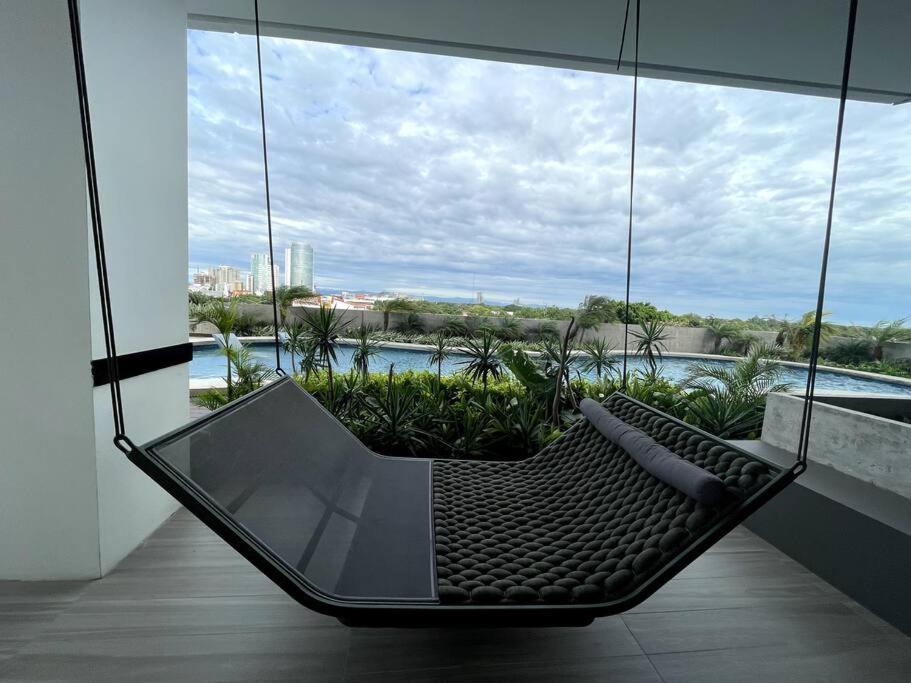 a swing in a room with a view of the water at Equipetrol Depto 1 Dorm piso 12 in Santa Cruz de la Sierra