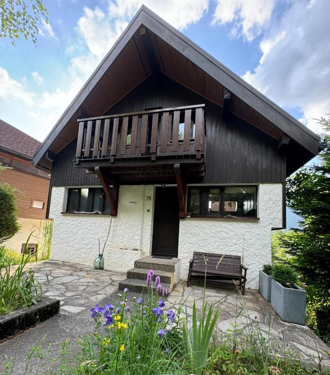 une maison avec un balcon au-dessus dans l'établissement Studio neuf rez de jardin dans chalet individuel, à Thollon-les-Mémises