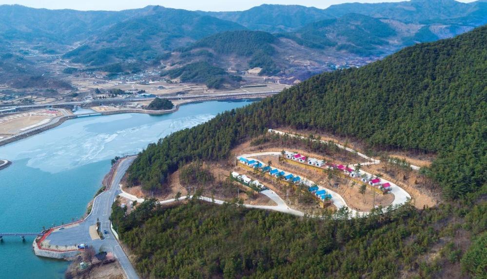 an aerial view of a resort on a hill next to a river at Gurye Jirisan Hosu Resort Pension in Gurye
