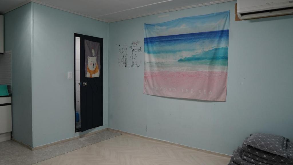 a room with a painting on the wall next to a door at Gapyeong Gumuchon Amusement Park Pension in Gapyeong